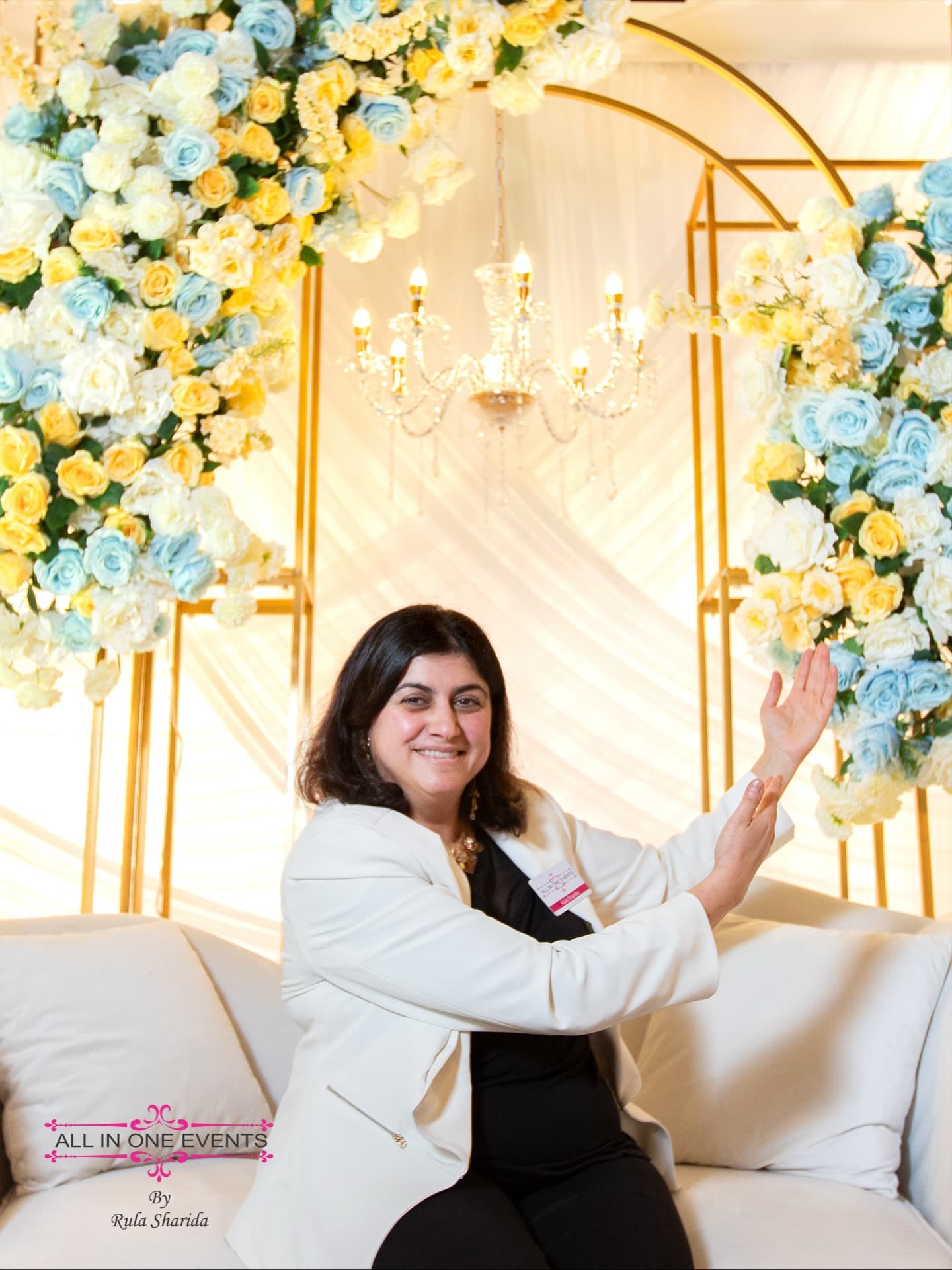 Rula Sharida seated beside blue and yellow floral wedding décor