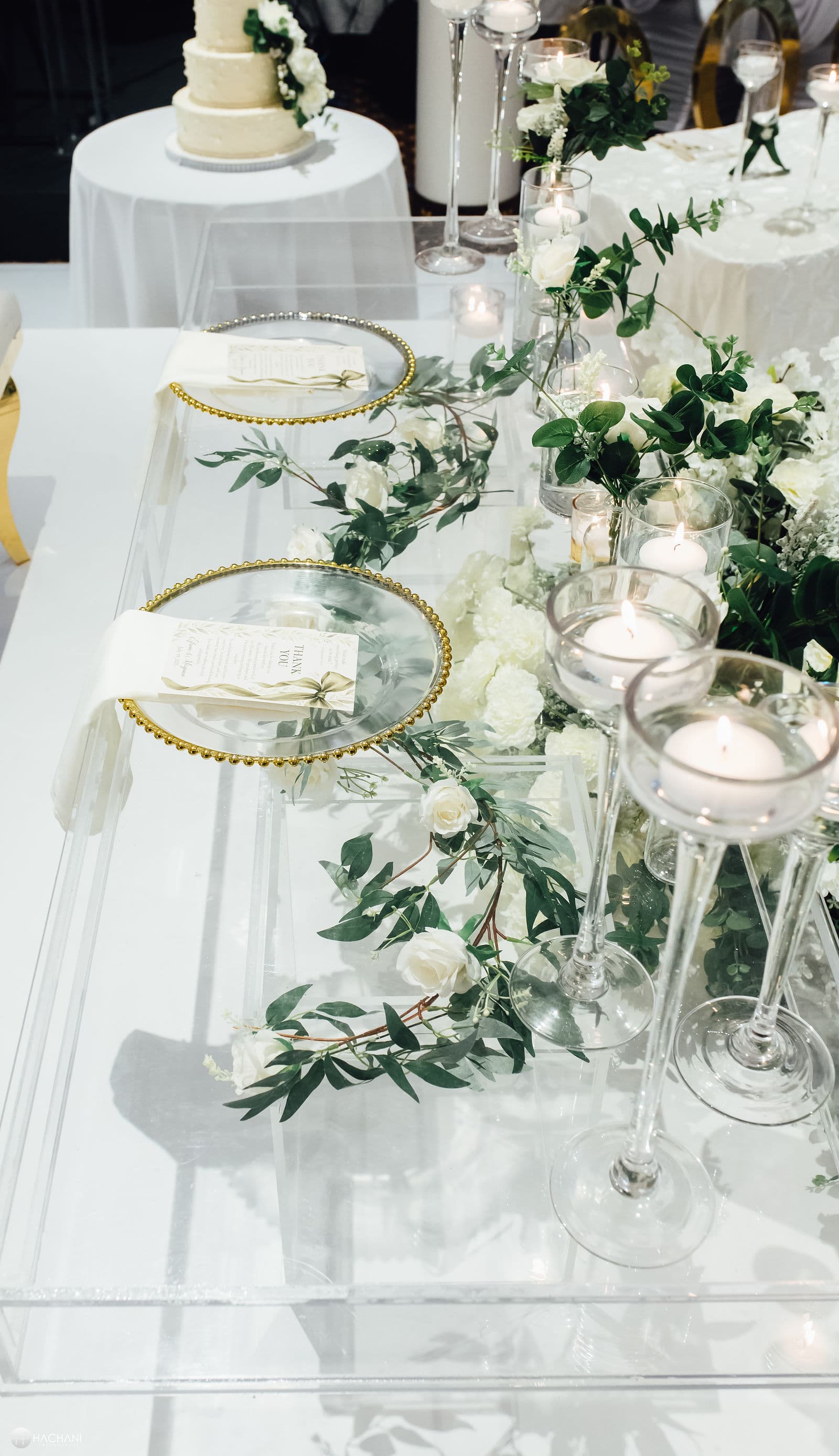 Wedding cake beside a candlelit reception table